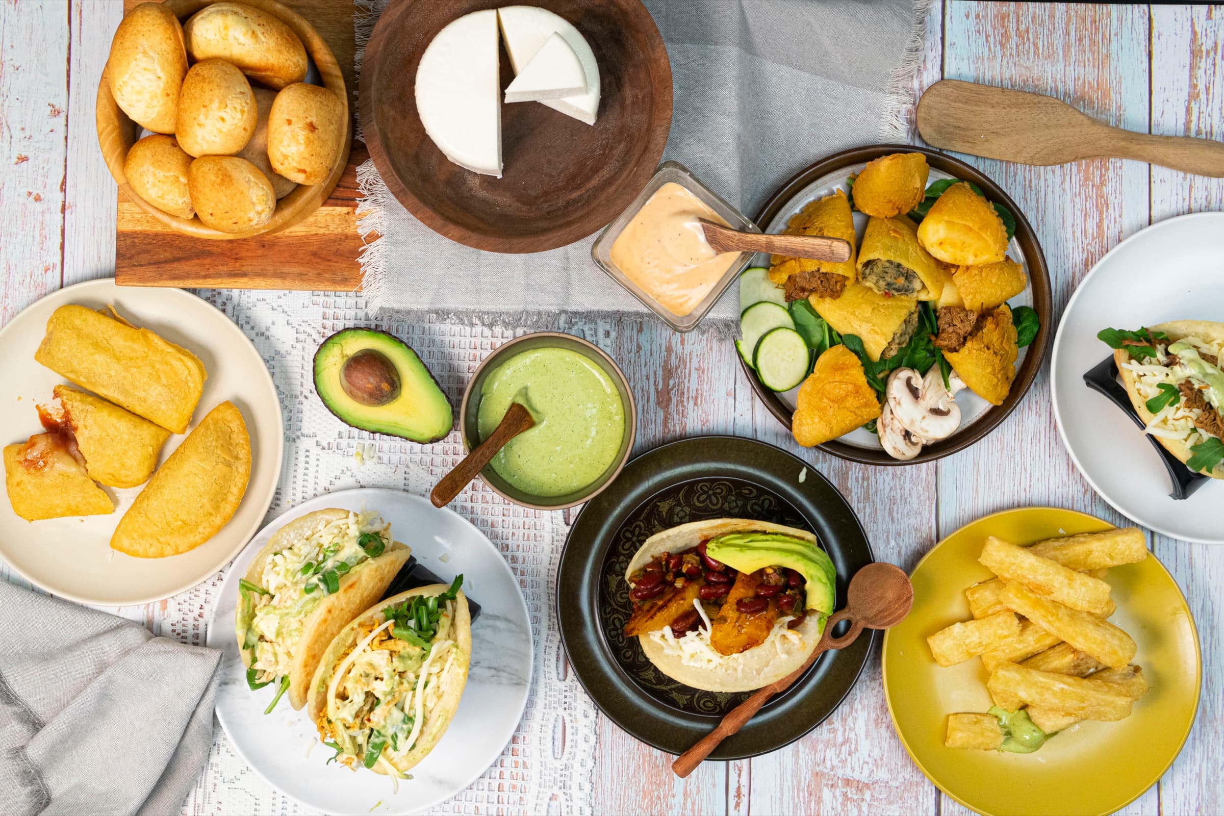 Pandebono, empanadas, arepas, patacones and yuca fries laid out on a table